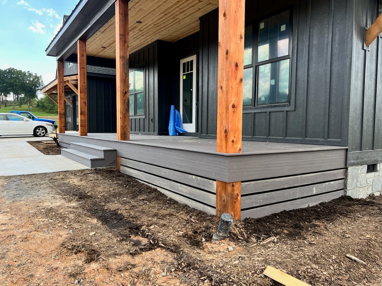Horizontal skirting stained a warm brown on a second house, set tight against a cedar post below a composite deck rim, with an even reveal gap between boards.